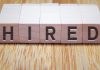 Wooden blocks that spell out the word hired