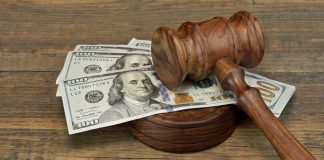 A judges gavel sits on a pile of dollars