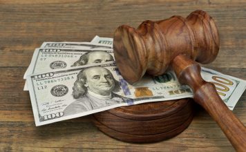A judges gavel sits on a pile of dollars