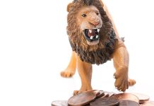 Plastic toy lion and a pile of pennies