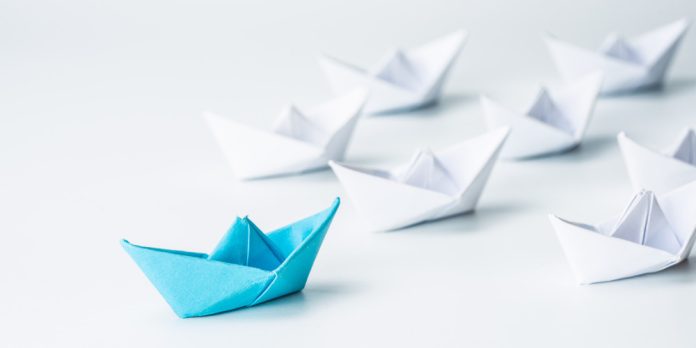Leadership concept with blue paper ship