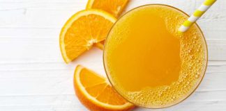 Glass of orange juice with orange rinds