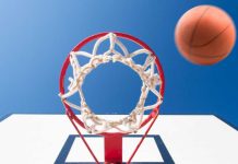 shot under a basketball rim with a ball mid-air