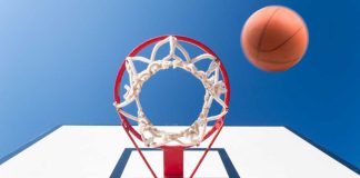 shot under a basketball rim with a ball mid-air