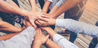 A diverse group of arms in a huddle