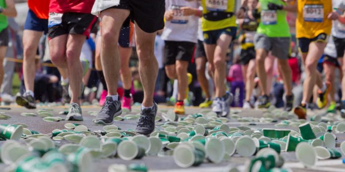 Boston Marathon runners with cups on the ground