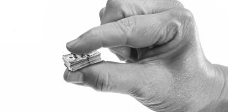 Hand holding shrunken US money