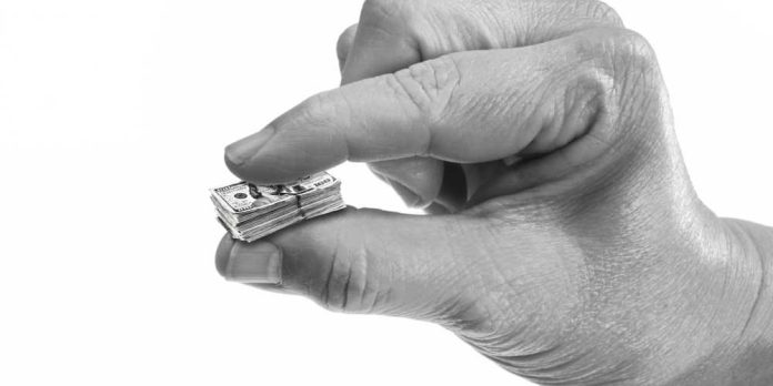 Hand holding shrunken US money