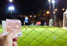 Hand with Euros in front of soccer game