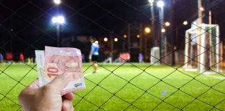 Hand with Euros in front of soccer game