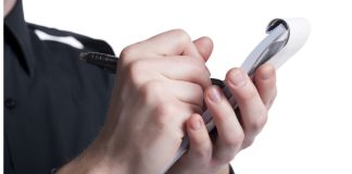 MA regulators issue $50K in fines for retail sports betting violations Officer writing a ticket