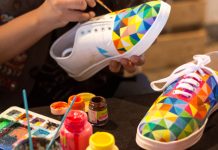 Hands painting colors on shoes