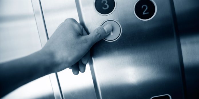 Hand pushing elevator button