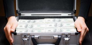 Bally’s chairman makes another offer to take company private Hands holding suitcase full of money
