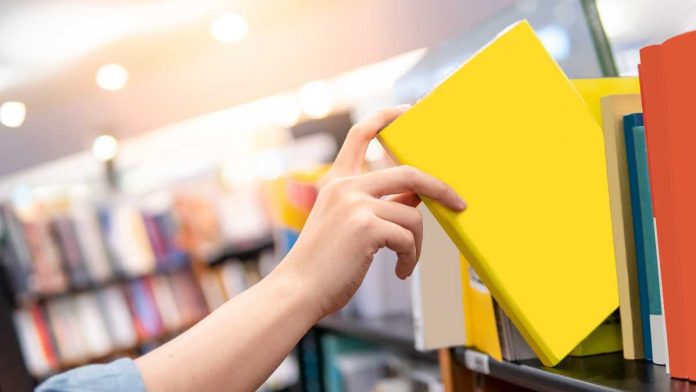 Hand pulling book off shelf