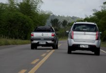 A pick up truck overtakes a car