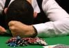 Forlorn gambles rests his head on a poker table