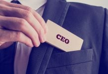 Man slides paper with CEO written on it into his suit jacket pocket