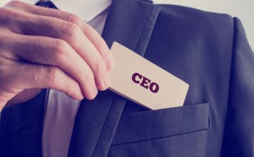 Man slides paper with CEO written on it into his suit jacket pocket