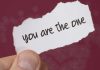 A person holds a piece of paper that says you are the one