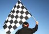 A man holds a chequered flag