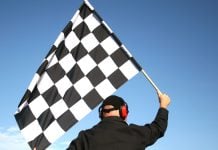A man holds a chequered flag
