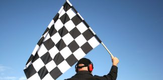 A man holds a chequered flag