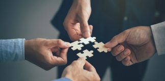 4 hands piece individual puzzle pieces together