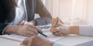 OpenBet, IMG Arena parent Endeavor going private in $13B deal Close up of two people looking at contracts