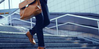 A man in a suit walks down a set of stairs