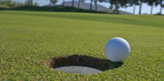 Golf ball going into hole