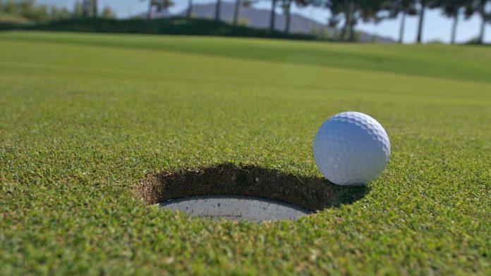 Golf ball going into hole