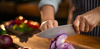 Close up of someone cutting an onion