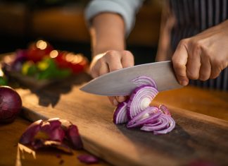 Close up of someone cutting an onion