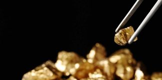 Tweezer picking up gold nugget