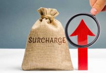 Robins defends DraftKings’ choice to add betting surcharge in some states Bag with surcharge written on it