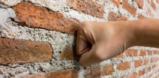 Hand hitting a brick wall