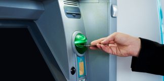 EDGE Markets signs deal with Defy the Odds for finance platform as person puts debit card into ATM