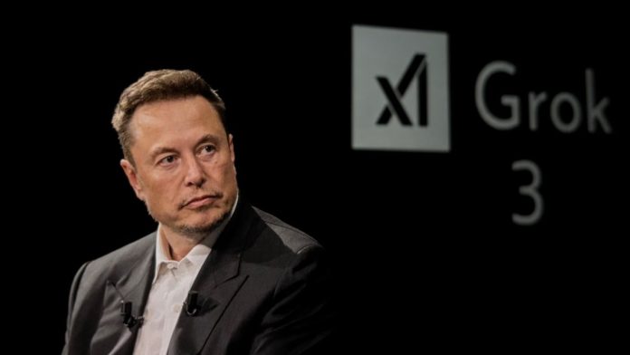 Elon Musk in front of the logo of xAI, which has partnered with prediction markets platform Kalshi