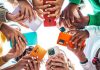 Hands holding cellphones in a group symbolizing second social gaming trade group