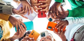 Hands holding cellphones in a group symbolizing second social gaming trade group