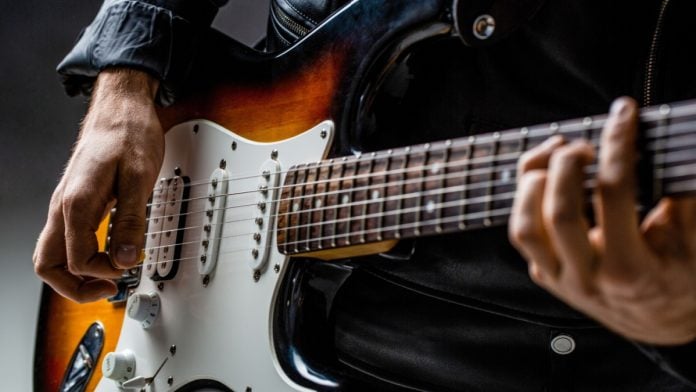 Guitar player holds instrument with Bragg Gaming securing a content deal with Hard Rock Bet.