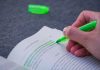 A person highlighting text in a book