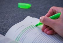A person highlighting text in a book