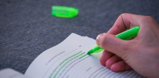 DraftKings highlights lllinois tax hike in reasoning for PAC filing A person highlighting text in a book