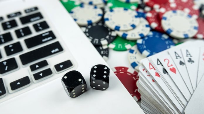 Computer with dice and deck of cards as Maine considers online casinos.