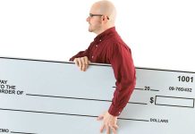 A person holds a blank check representing the Publishers Clearing House.