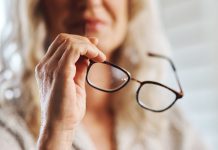 Woman handles eye glasses as PlayAIO shares visibility data on online casino games.
