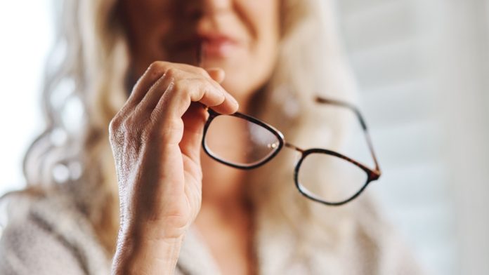 Woman handles eye glasses as PlayAIO shares visibility data on online casino games.