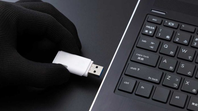 Gloved hand with flash drive symbolizing corporate espionage
